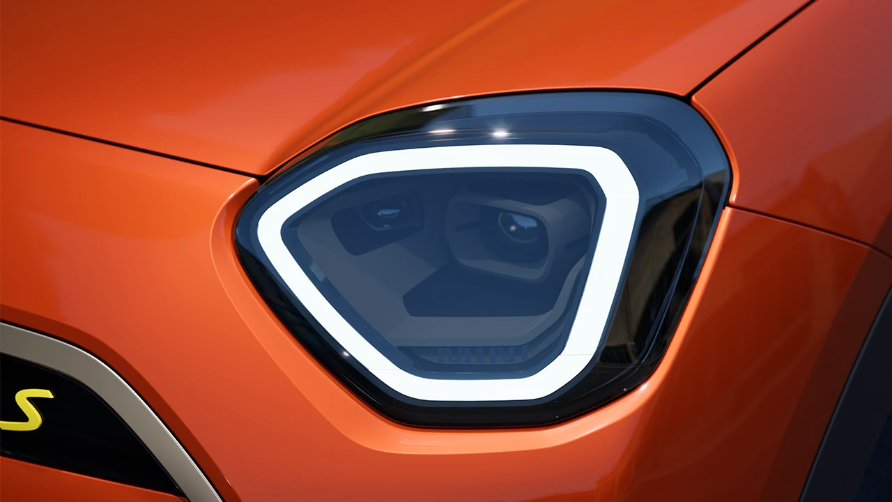 Detail van de koplamp van de MINI Aceman Electric met wit licht aan