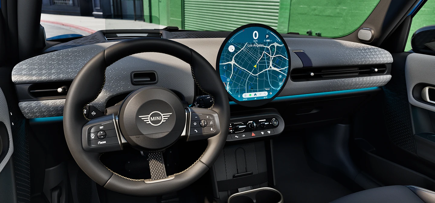 Vue de l’intérieur de la MINI Cooper 5 portes mettant l’accent sur le volant, le tableau de bord et l’unité d’interaction.