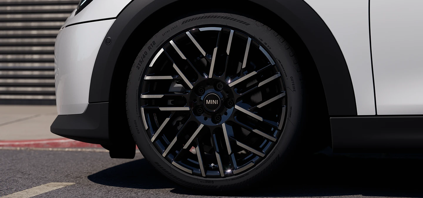 Plan rapproché de la MINI Cooper 5 portes Nanuq White avec jantes bicolores Night Flash Spoke.