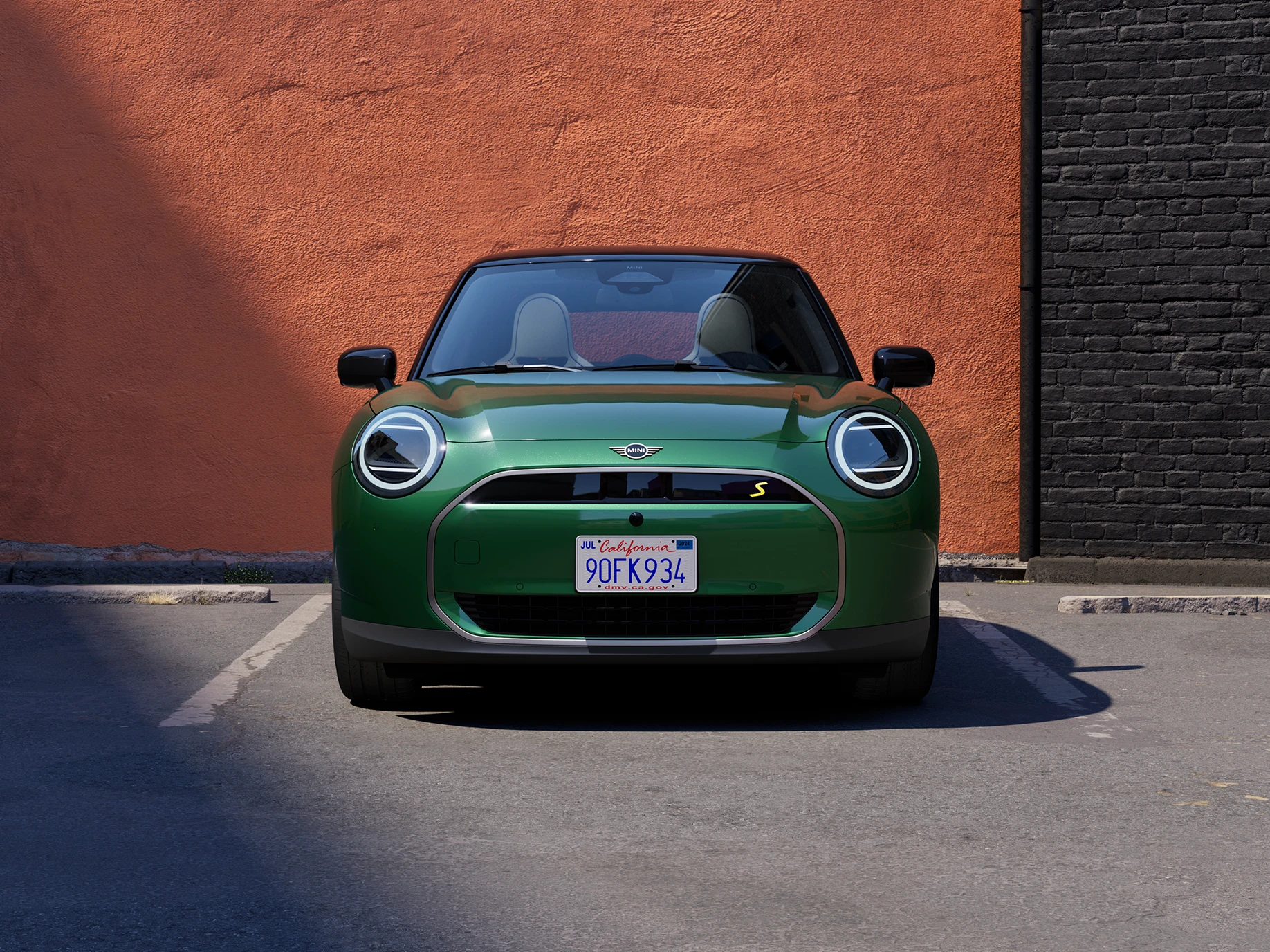 Vooraanzicht van een MINI Cooper Electric in British Racing Green en Black Roof.