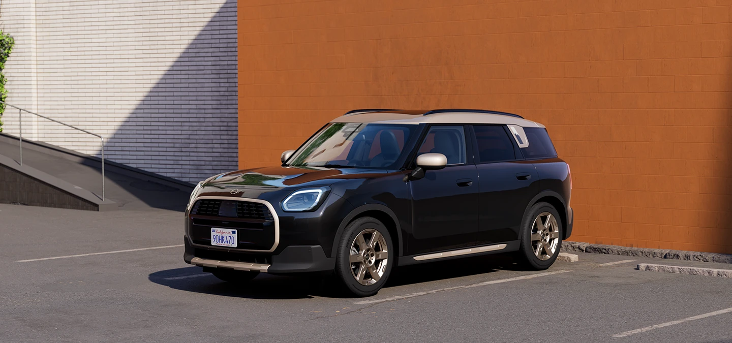 Vue avant latérale de la MINI Countryman Midnight Black avec toit Vibrant Silver stationnée.