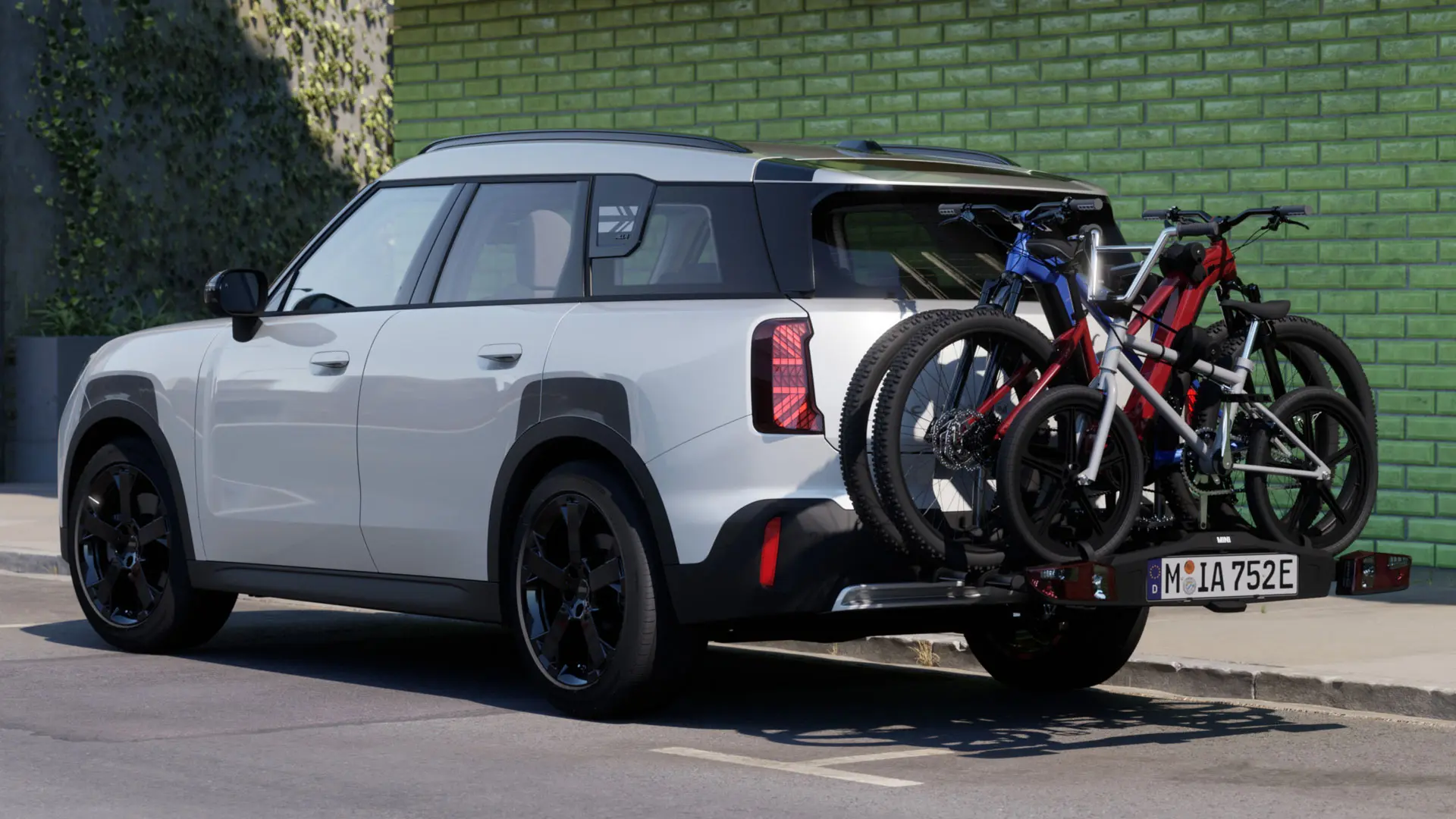 MINI Aceman en Nanuq White équipée d'un porte-vélos arrière MINI Pro 3.0, transportant deux VTT et un vélo pour enfant.