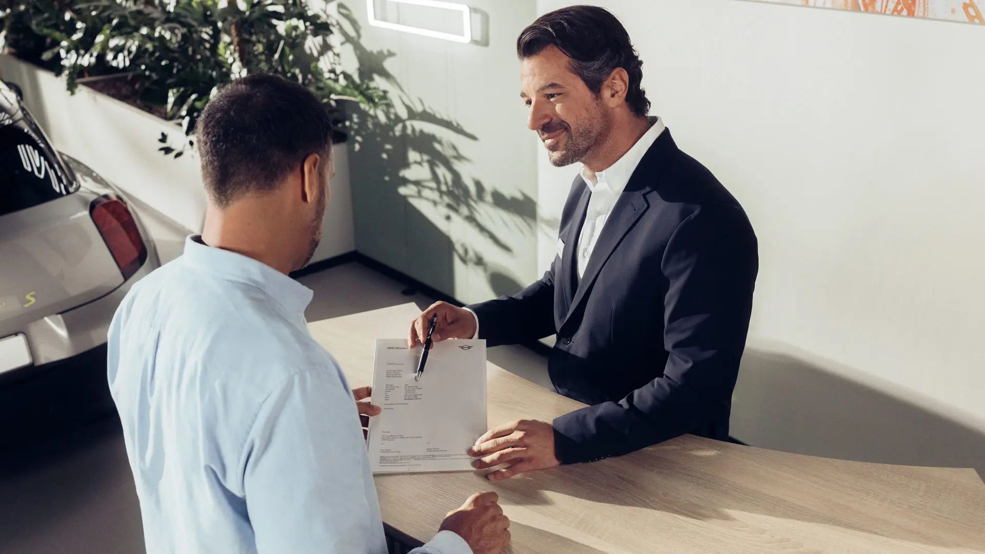 Een service-assistent van een MINI partner adviseert een klant welke opties er zijn qua MINI bandenverzekering.