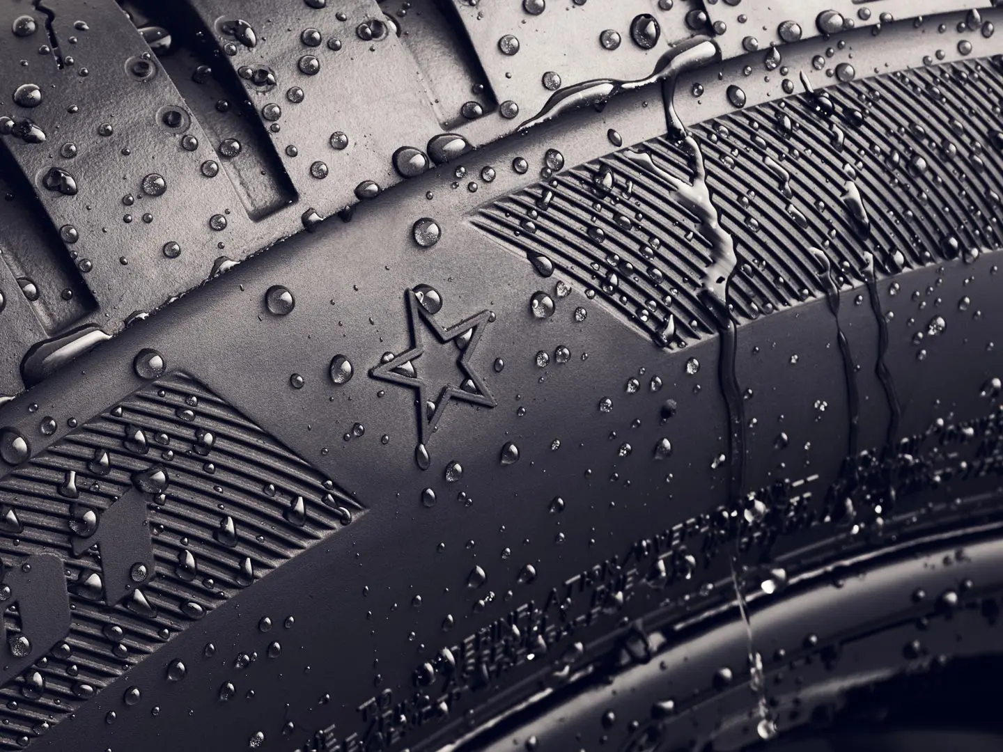 Close-up van de zijwand van een band met de stermarkering, waaruit blijkt dat deze band is goedgekeurd voor optimale prestaties op MINI voertuigen. 