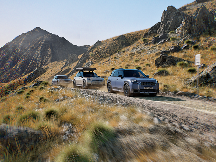 Photo montrant plusieurs MINI Countryman Untamed Edition roulant hors route sur une route de montagne.