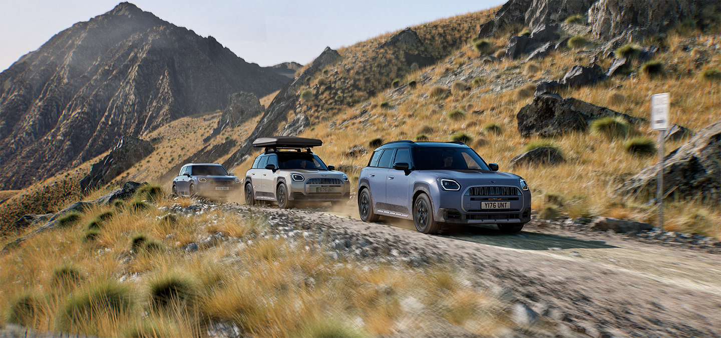 Photo montrant plusieurs MINI Countryman Untamed Edition roulant hors route sur une route de montagne.