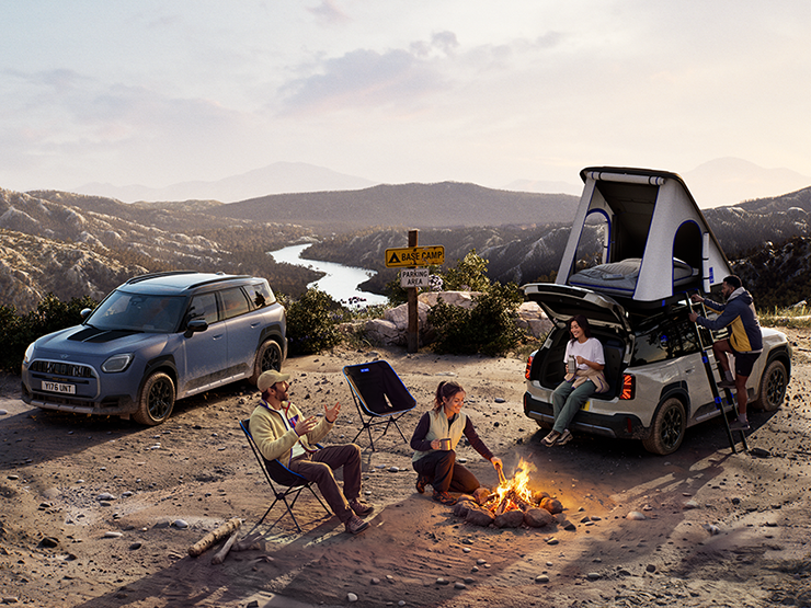 Photo de deux MINI Countryman Untamed Edition sur une montagne au coucher du soleil.