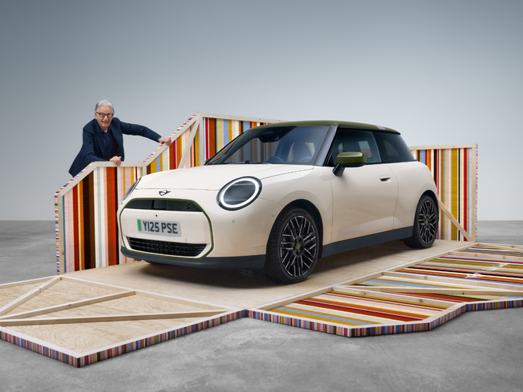 Vooraanzicht van de volledig elektrische MINI Cooper Paul Smith Edition in de kleur Inspired White met ontwerper Paul Smith
